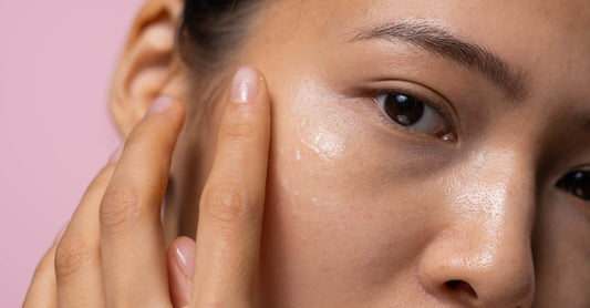 Woman applying face serum at vanity with glowing skin sign